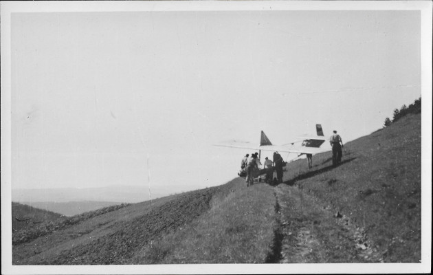 Na ernobl pohlednici malho formtu je zajmav zbr jak skupinka lid vlee na cest po svahu kluzk. Na zadn stran fotografie je napsno: Chlum u eran,
lto 1946, bezmotor. ltn Arnot. Jak je uvedeno i v nadpisu k fotografii. Skupinka lid si vyv na kopec kluzk, aby s nm nsledn jeden z nich sltl do dol.  
Na cestu do svahu maj podvozek. Do vzduchu jej mohou vythnout napklad pomoc gumovho lana. Ke startu kluzku budou potebn vichni.