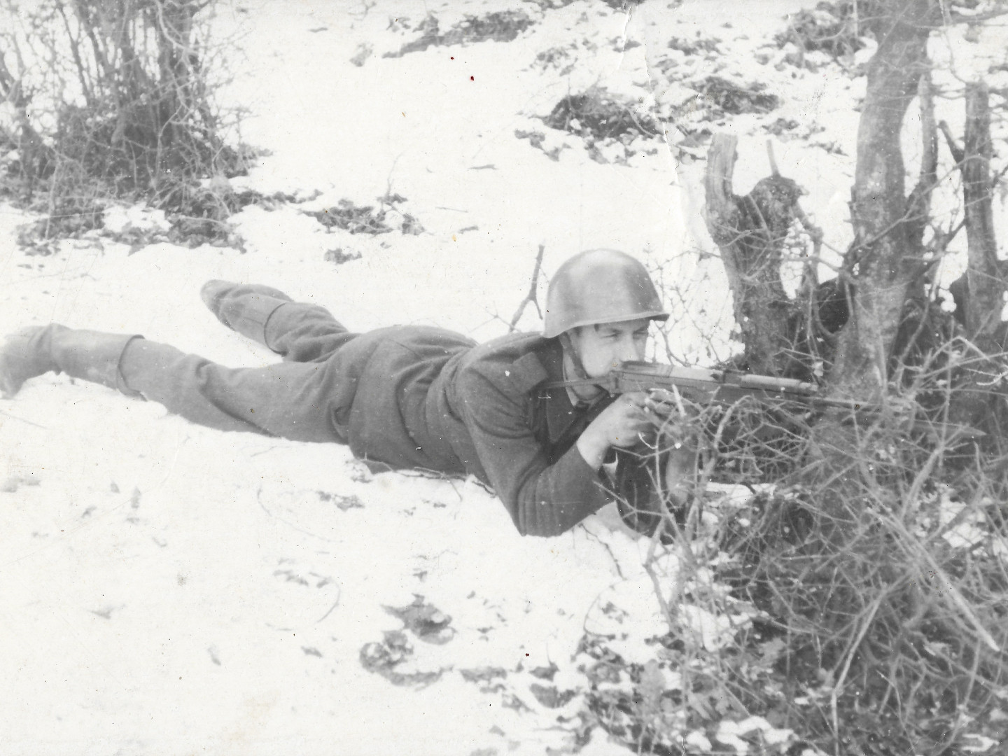 Na fotografii velkho formtu je zachycen vojn v khaki poln uniform lec pipraven ke stelb na snhu za keem.
  na hlav m plbu vz.53.