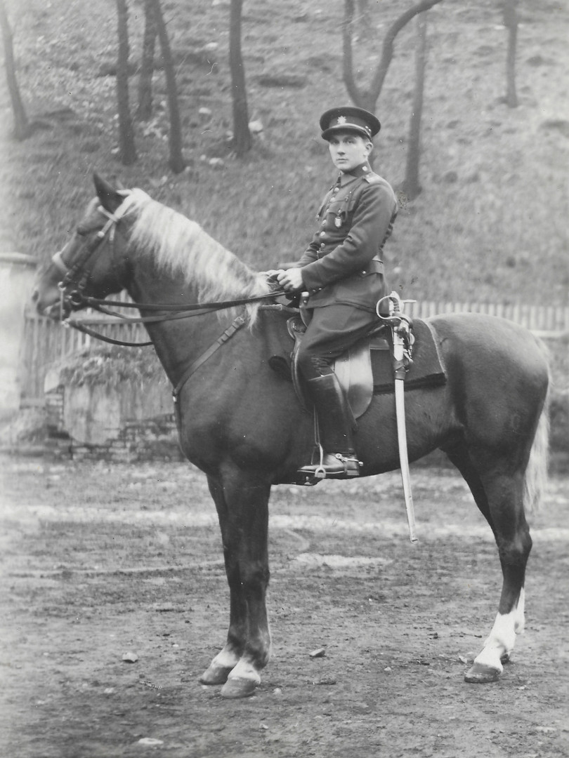 Na fotografii je dragoun na koni. Na hlav m kulatou epici. Po boku m dlouhou avli. V pozad je 
taras, plakov plot a svah s mladmi stromky. Z nich se do zbru vely jenom kmeny.