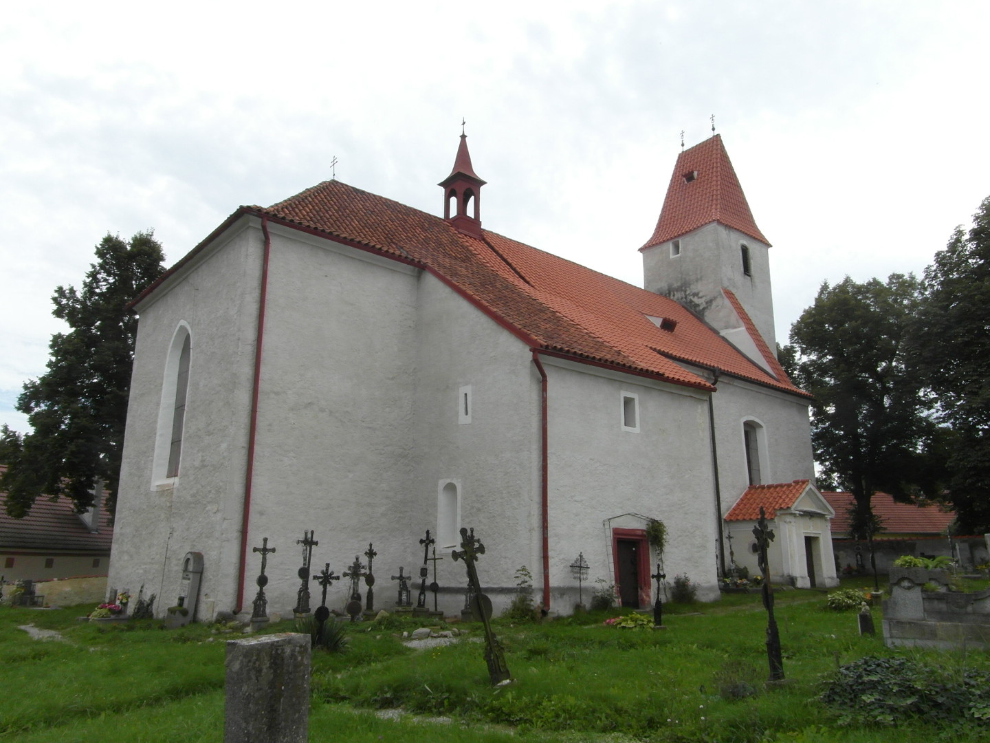 Na zbru fotografie je kostel sv. Jakuba Starho od severu. Fotografie je udlna ze vzdlenj sti hbitova. 
  Je vidt zatravnnou plochu s cestami, litinovmi ki a nkolika hroby i jenom nhrobky. Vzadu jsou kolem kostela
  stromy.