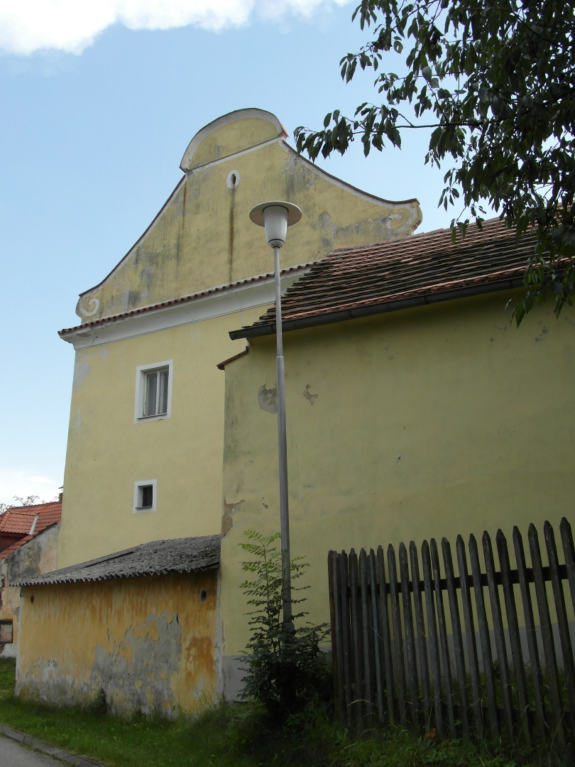 Na fotografii z vletu je elo budovy zmku, kousek hospodskch budov, lampa veejnho osvtlen
      a devn plakov plot.