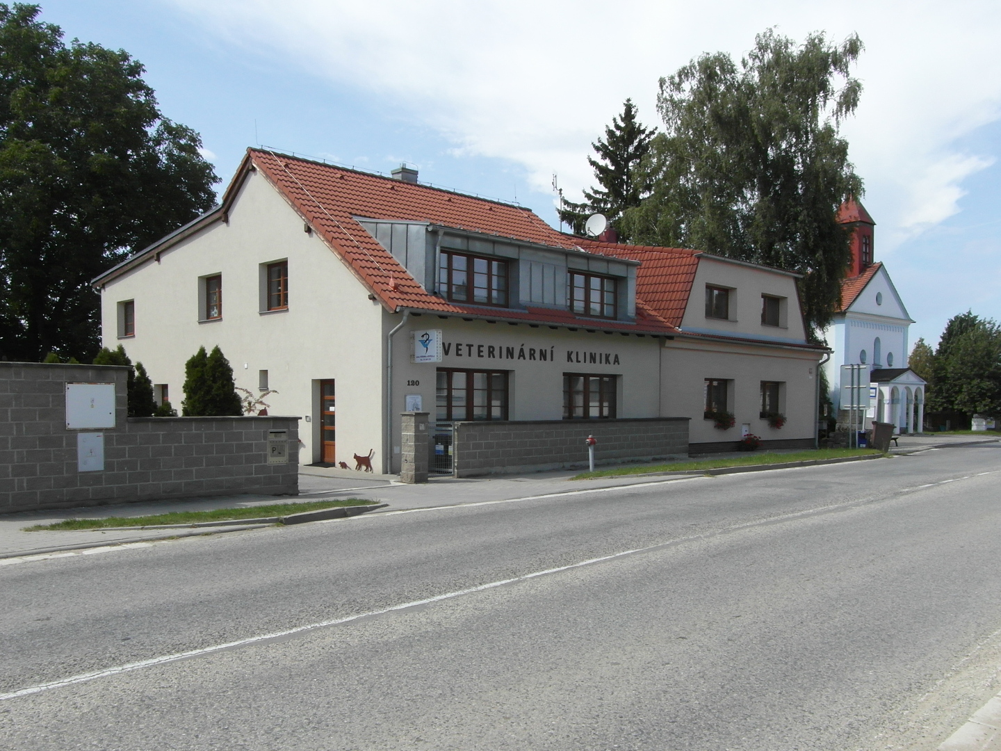 Na fotografii z vletu je ed budova veterinrn kliniky. V zbru je z velk sti silnice.
      vlevo i napravo jsou mohutn listnat stromy a jeden smrk. pln vpravo vynv kostel Panny Marie
      Krlovny Andl.