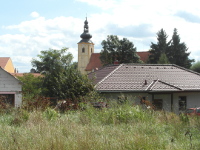 Kostel na fotografii je z vt vzdlenosti
          z vysokmi trvami zarostl plochy za parkem. Mezi kostelem a mstem fotografovn
          je novostavba a vedle n jet nco rozestavnho.