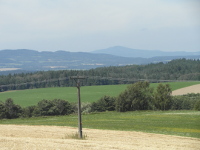 Na fotografii z vletu jsou pole, louky, lesy a v
          dlce kopce. Tak je na n veden vysokho napt.