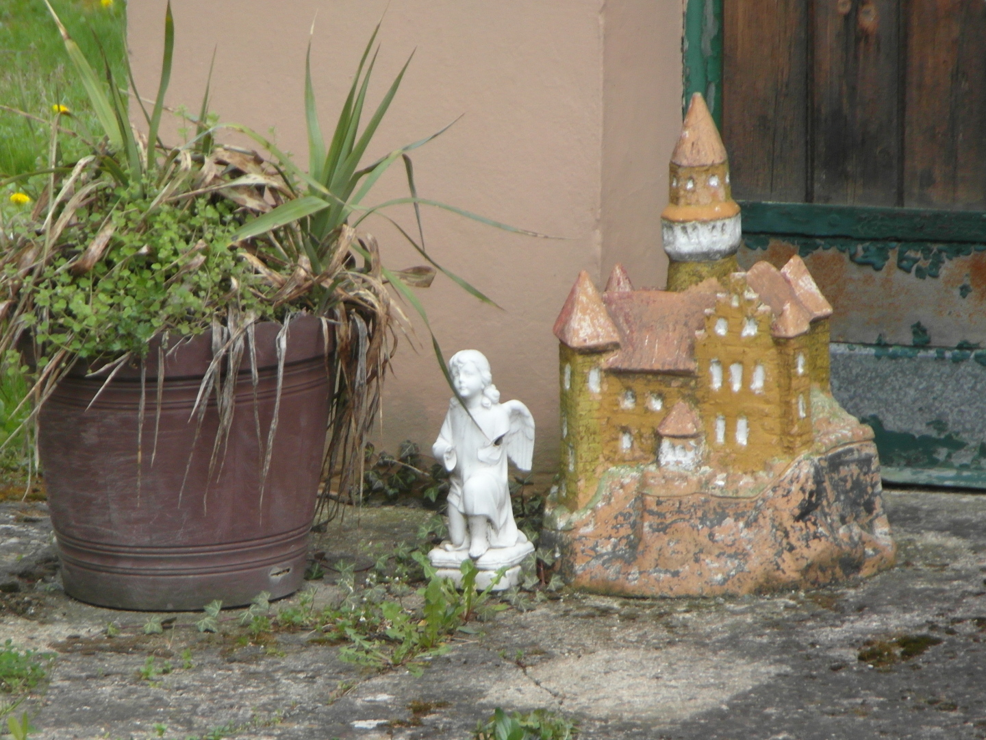 Na tento piblen zbr se veel hnd plechov kvtin, bl andl a miniatura tak, e zabraj celou plochu
  fotografie. Andl m ulomenou ruku. Hrad je zeteln viditeln i s nktermi detaily. Stny hradu jsou nateny okrovou
  barvou. Stechy jsou erven. V je stupovit. Pod doln stechou je ble naten ochoz. Ble naten je i jaksi
  pstavek v doln sti hradu. Skla, na kter se miniatura hradu nachz je sice natena edou barvou, ale je velmi
  otluen a na svtle hnd hlinn podklad.