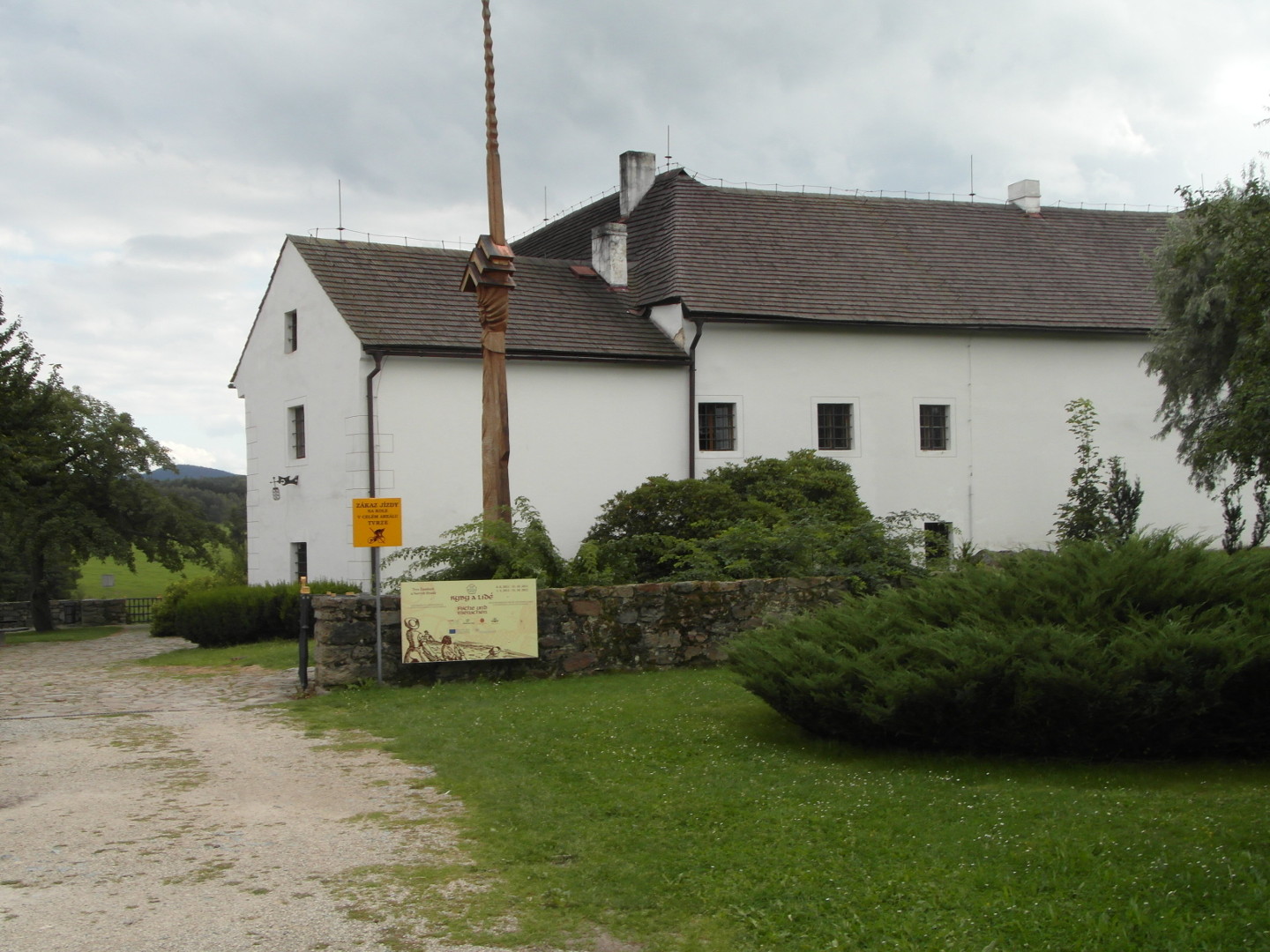 Na zbru fotografie z vletu je vt st tvrze od severu. Tvrz je omtnuta blou barvou. Je vidt pchoz cesta, trvnk, 
  kee zdka ped tvrz, naun cedule, devn artefakt a nkolik zamovanch oken.