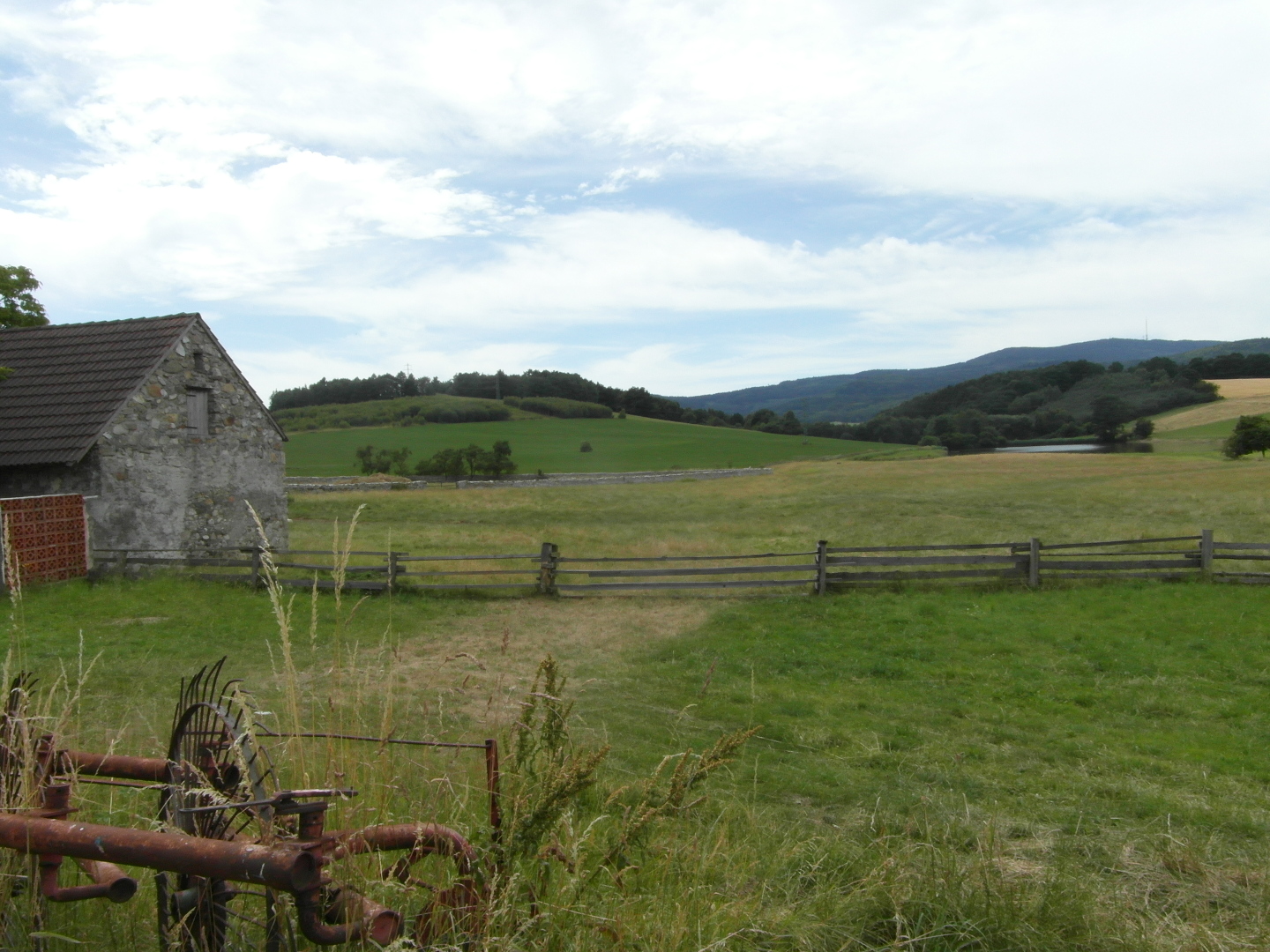 Na fotografii je krajina. Jsou vidt louky, lesy, ohrada, rezavjc star 
       zemdlsk stroj, rybnk, na map nepojmenovan kopec (567) a na obzoru CHKO Blansk 
       les s horou Kle (1 084). Tak je vidt tt hospodsk budovy.