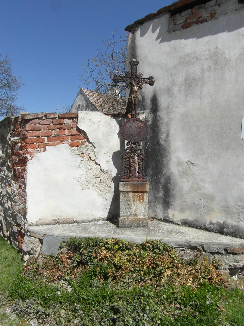 Na fotografii z vletu jsou elezn Bo muka na kamennm podstavci.
            Je zachycen i trvnk a zdky kolem nich. Jsou cestou od tvrze pes silnici.
            Je na nich Je Kristus, ovln cedule s neitelnmi npisy a Panna Marie.