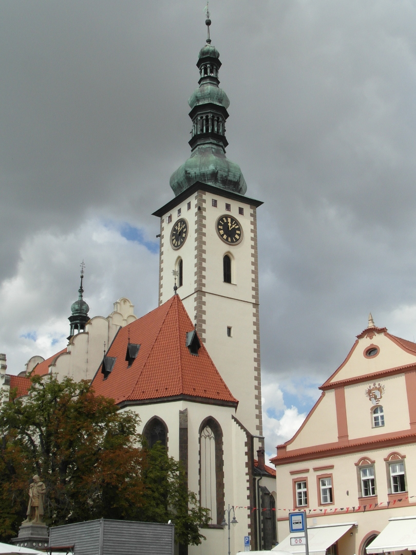 Na fotografii je v a lo kostela Promnn Pn. Kostel je bl. Na vi jsou bn pokryt mdnkou. st lodi kostela zakrv
  strom. Napravo je st domu. Dm m bledou rovou barvu s ervenou vzdobou.