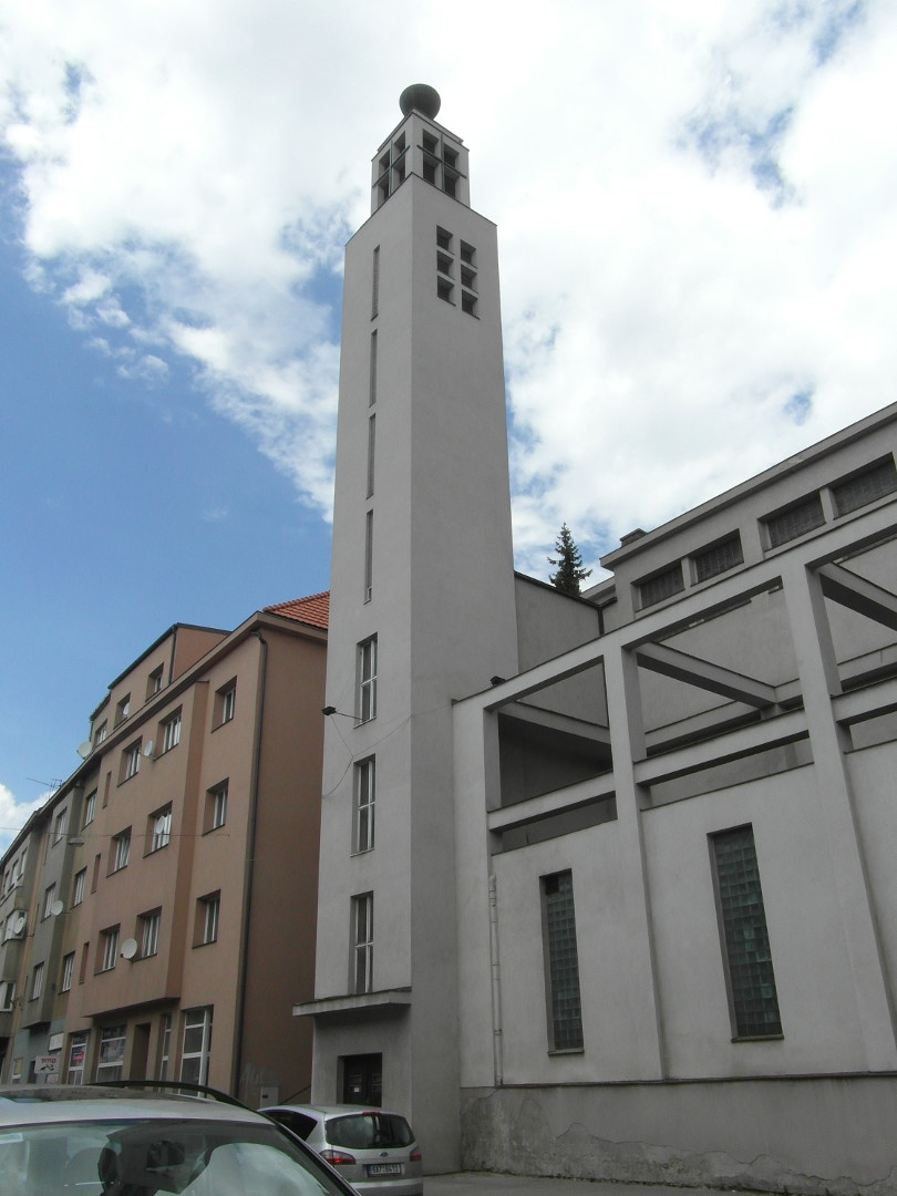 Na zbru je v se zpadn st lod a terasy nad kolumbriem z Budjovick ulice. pln vlevo je okrov omtnut dm. V mezee mezi 
  nm a v sboru je zmiovan schody, kter vedou nahoru do Farskho ulice, a tm umouje nvtvu sboru z ulice Budjovick. Schody na
  fotografii nejsou vidt. Sbor m edoblou fasdu. V je thl s tvercovou podstavou. Na jejm pat jsou irok dvee s pstekem. Jin 
  strana ve m dole ti vysok okna (doln zan hned na stee psteku nad dvemi). Nad nimi jsou tyi velmi zk vysok okna. Horn, men, 
  st ve m z vchodu i z jihu jedno obdlnkov okno tm pes celou jej vku. Je dleno kem, kter je penv. Uprosted je st lodi 
  s odhalenou konstrukc nad terasou kolumbria. Konstrukce je tvoena propojenmi rmy, kter terasu i stnu kolumbria rozdluj na sti. 
  Lo m ji ve popsan velk obdlnkov okna vysoko nad konstrukc kolumbria. Terasa kolumbria m v kad sv sti velmi vysok obdlnkov 
  okno. Okna jsou opatena luxferami.